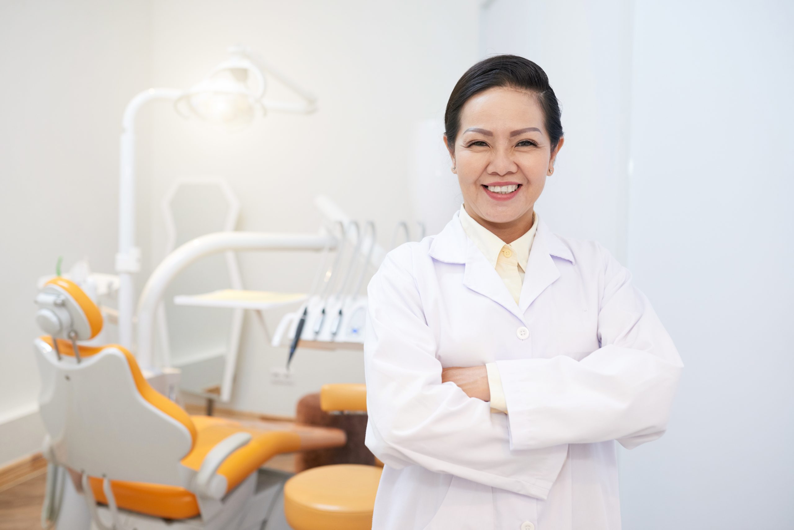 cheerful ethnic dentist in white gown 8HGXZSB scaled