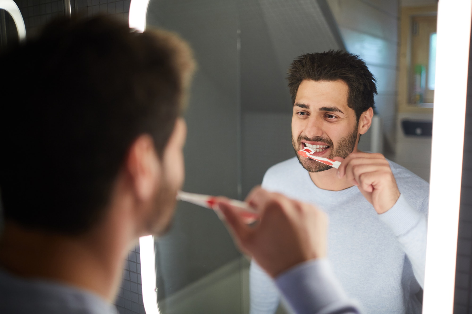 cheerful man cleaning teeth