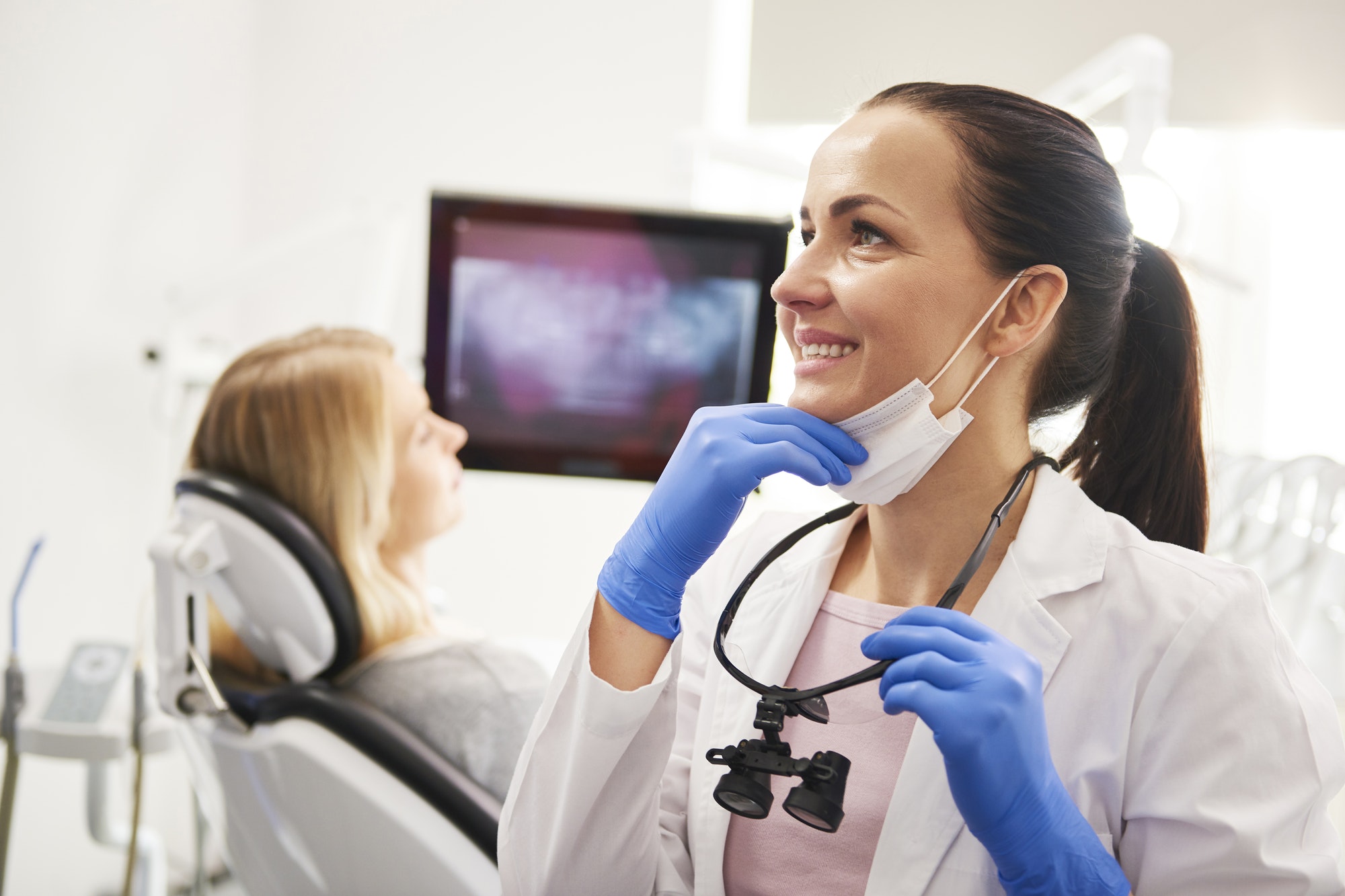 satisfied dentist with dental equipment doing her work in clinic