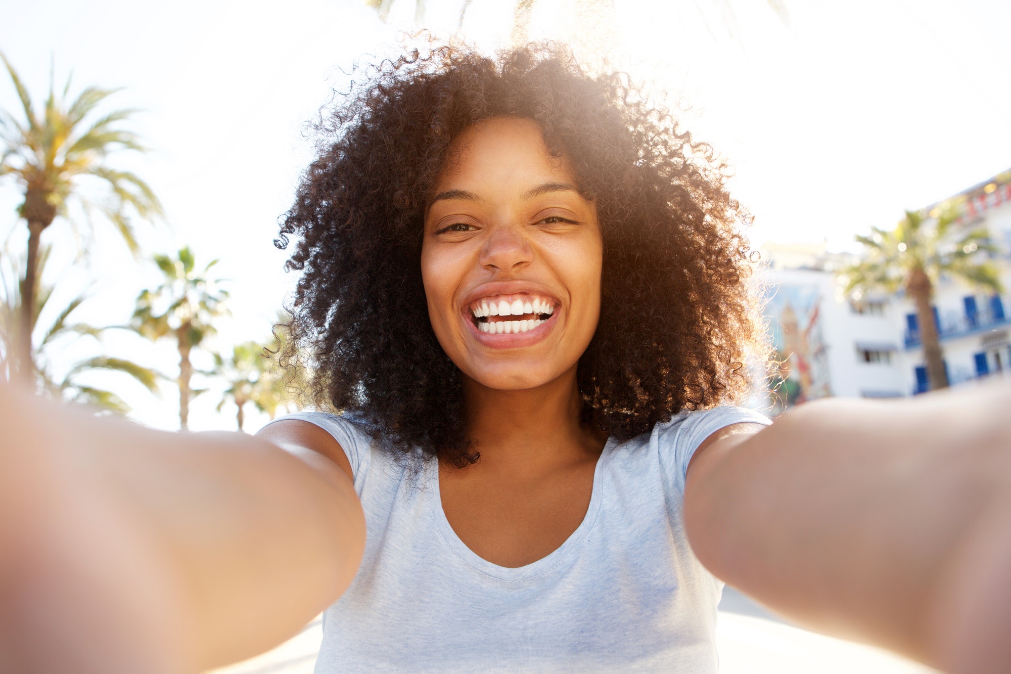 selfie of laughing black woman outside with curly hair