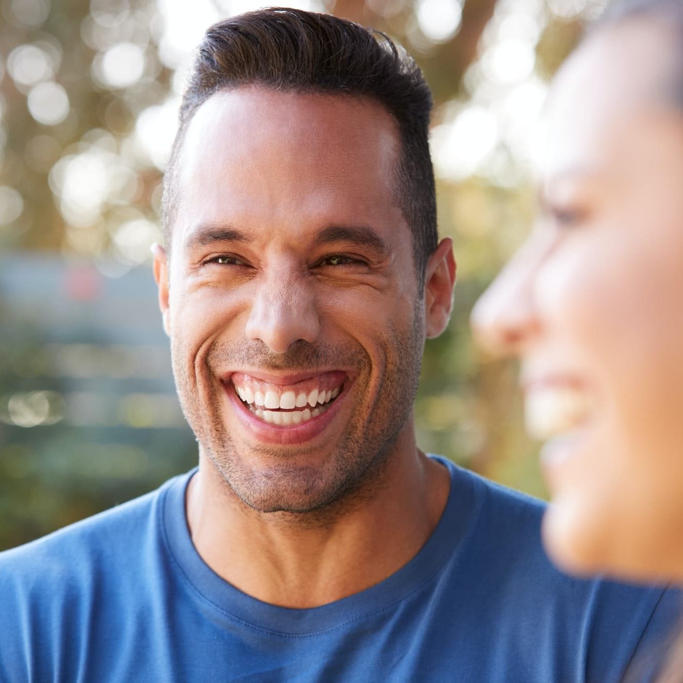 smiling hispanic couple talking and laughing in garden at home