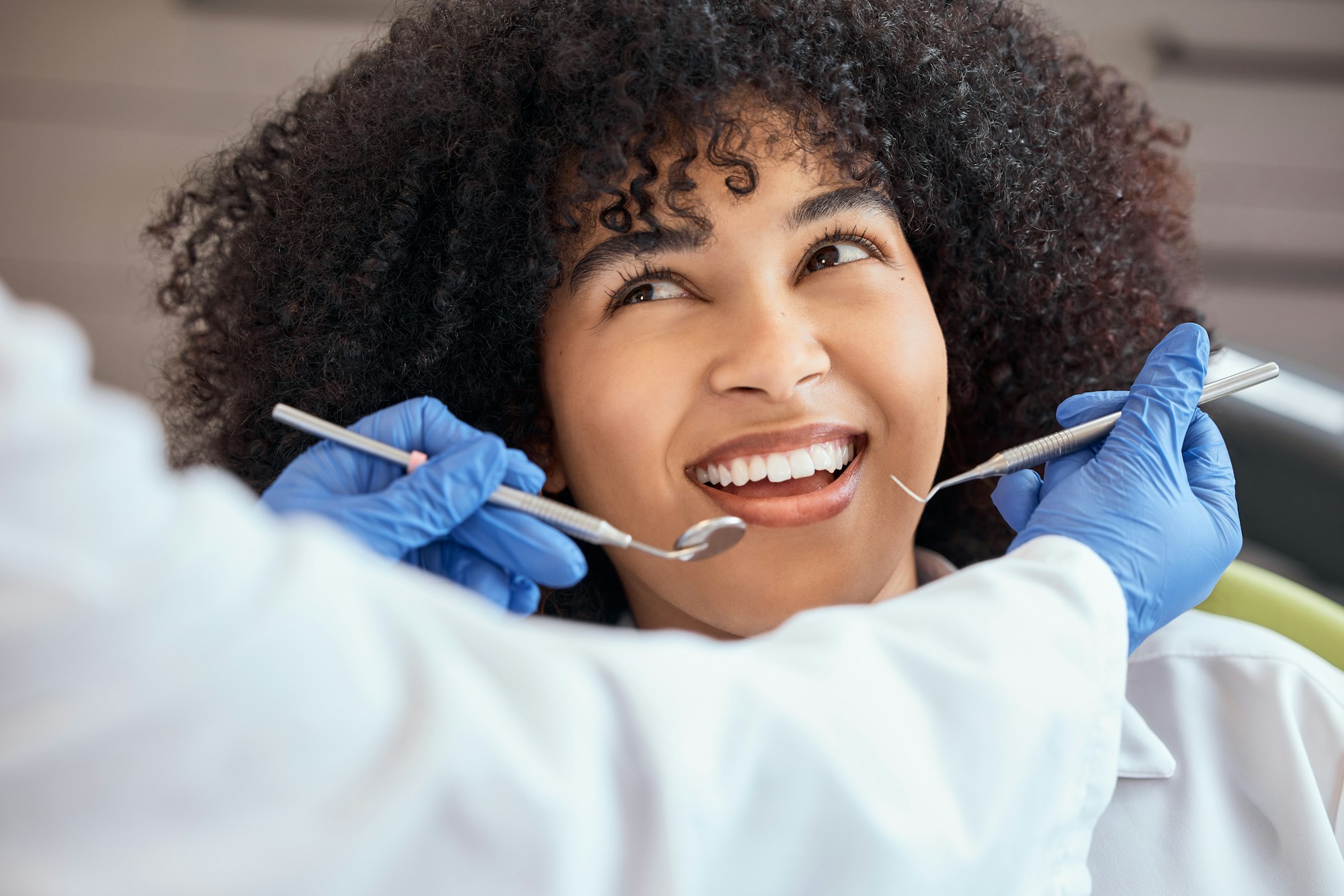 Above shot of a beautiful young african american woman with an afro looking at the dentist at her d