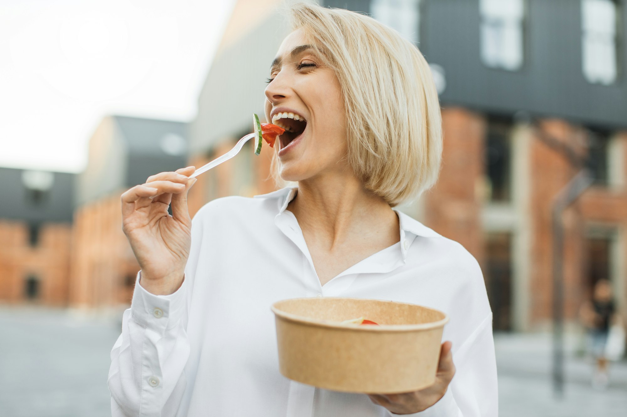 Female dieting nutrition concept. Attractive smiling girl enjoying veggie meal.