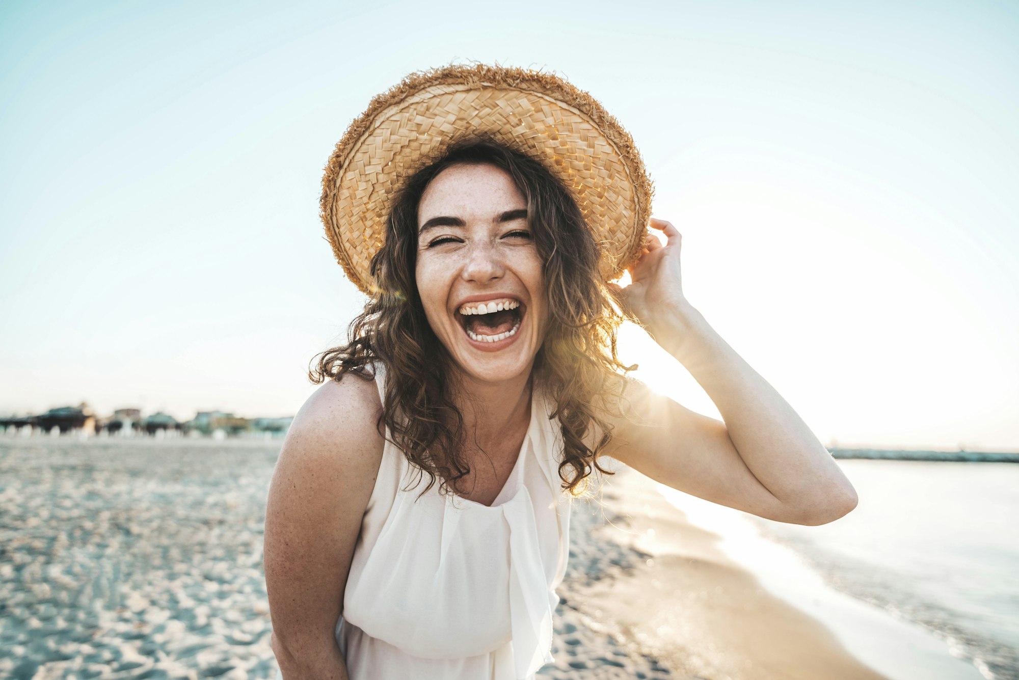 Happy beautiful young woman smiling at the beach side