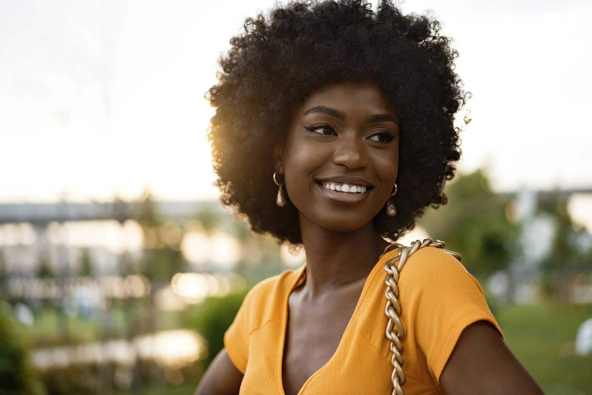 Portrait of a young african american woman smiling standing at the city.