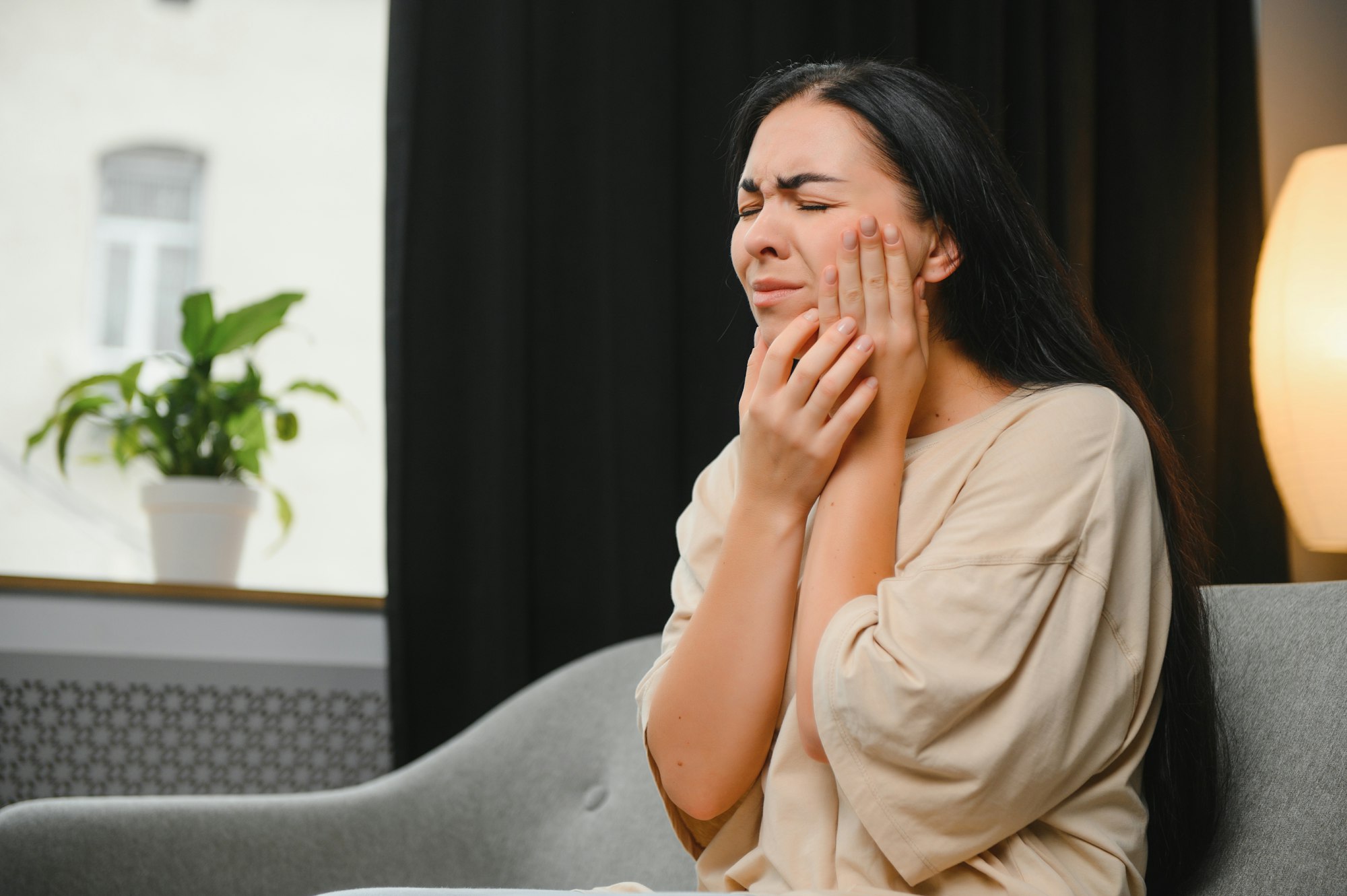 Woman with severe toothache touching her swollen cheek.